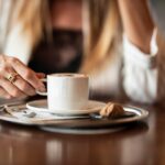Tazza di caffè fumante su tavolo, simbolo di relax dopo pranzo.