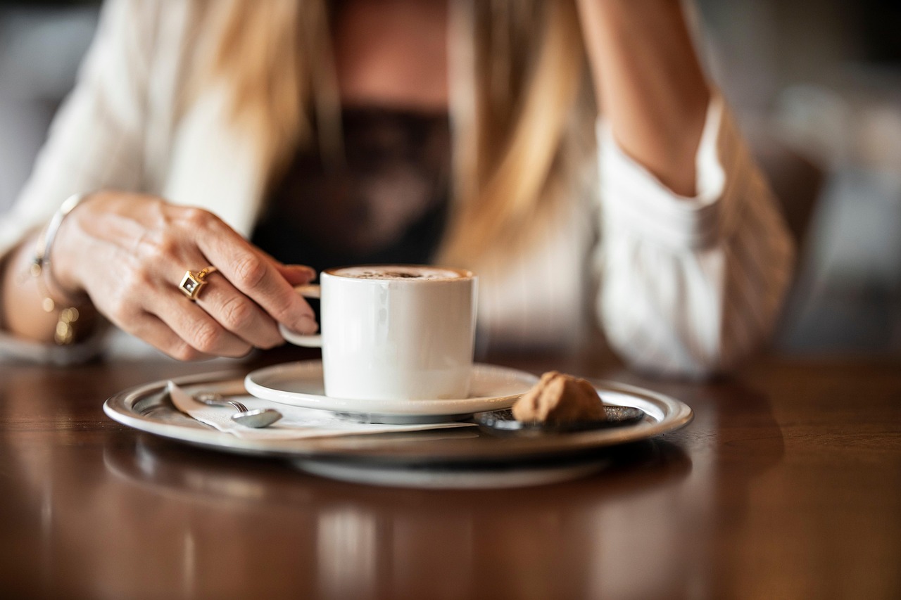 Tazza di caffè fumante su tavolo, simbolo di relax dopo pranzo.