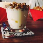 Yogurt in una ciotola con frutta, simbolo di benefici per l'intestino durante la notte.