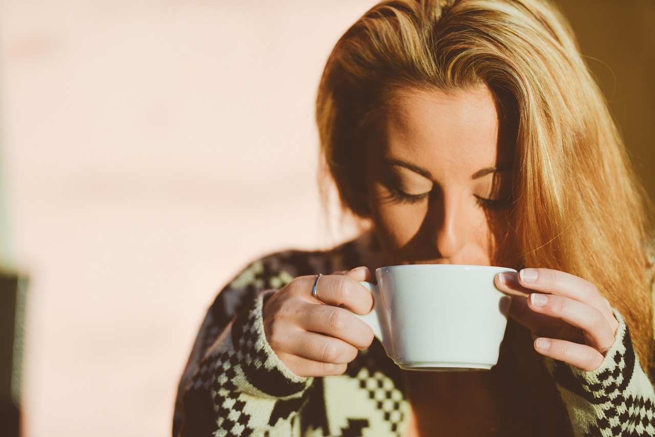 Tazza di caffè con chicchi, simbolo del legame tra consumo di caffè e vitamina D.