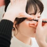 Makeup artist applica trucco occhi resistente al caldo in tre passaggi su modello.