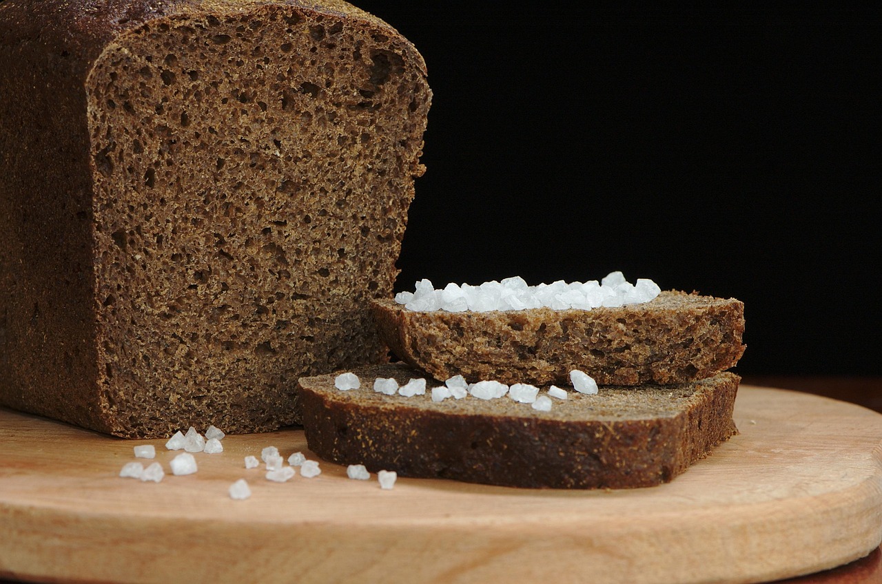 Pane fatto in casa senza sale, croccante e dorato, su un tavolo di legno.