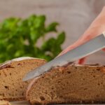 Fette di pane servite a cena con contorni, in un contesto di alimentazione serale.