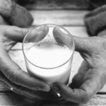 Immagine di una tazza di latte intero con un avviso di allerta per persone sopra i 60 anni.