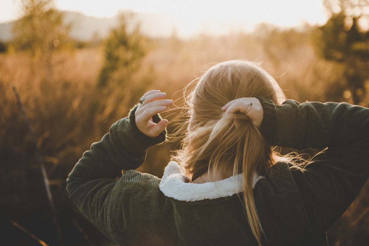 Donna con capelli fini raccolti con doppio legaccio, resistenti al vento estivo, senza nodi.