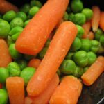 Due piatti con verdure crude e cotte, evidenziando le differenze nutrizionali.