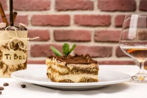 Tiramisù con crema al mascarpone, strati di savoiardi e cacao in polvere, decorato elegantemente.
