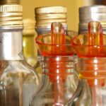 Confronto tra diverse bottiglie di oli vegetali su sfondo neutro, evidenziando salute e colesterolo.